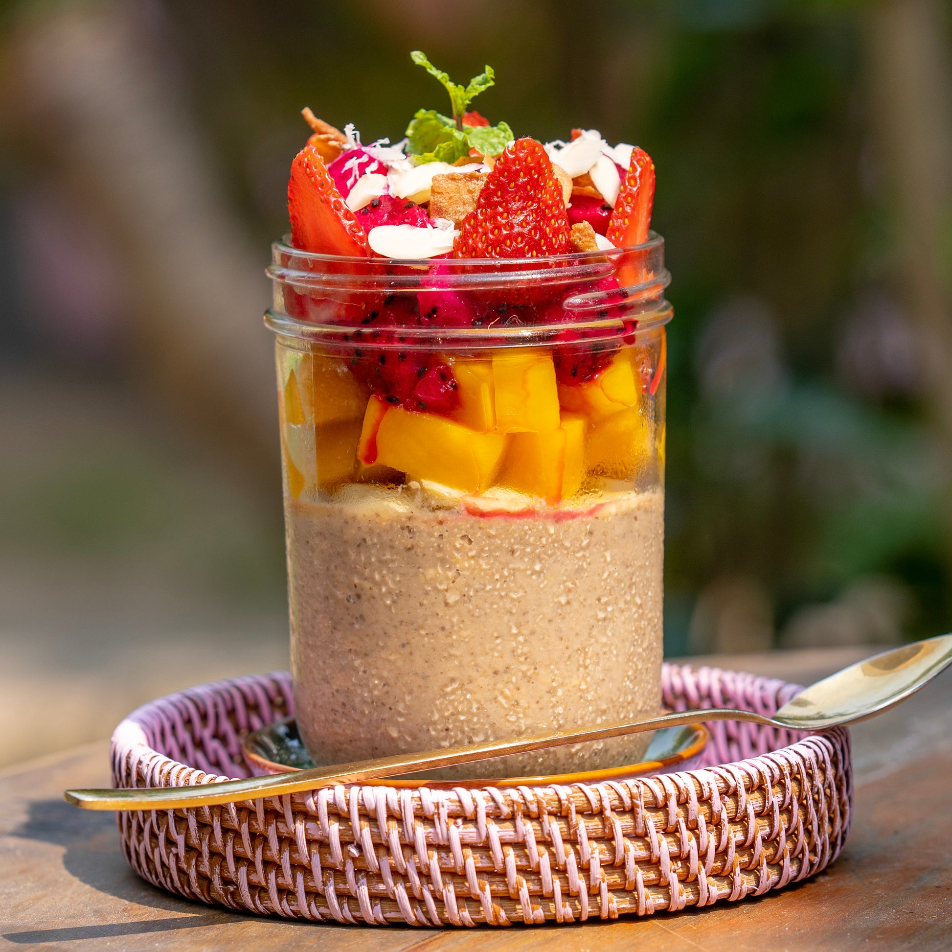 Wholesome Overnight Oats jar with slow-soaked whole oats, superfood chia seeds, bananas, and coconut milk, layered with a fresh mosaic of local mango, strawberries, and dragon fruit at YESH! Tribe | Eat & Vibe